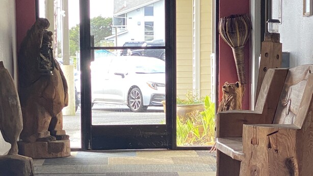 A reception area with a patterned carpet, a wooden bench, and a statue. - Ocean Shores Inn & Suites (Ocean Shores)