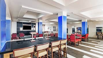 A modern conference room with a long table, red chairs, and a blue accent wall.