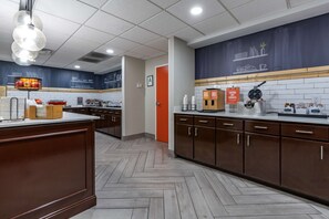 A modern kitchen with wooden cabinets, a herringbone floor, and a chalkboard wall. - Hampton Inn & Suites Louisville East (Louisville)