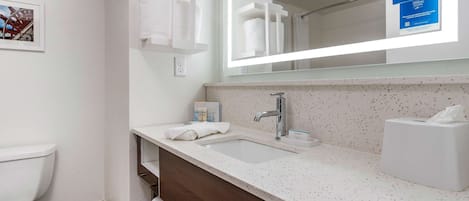 A modern bathroom with a white toilet, a sink with a mirror above it, and a towel rack.