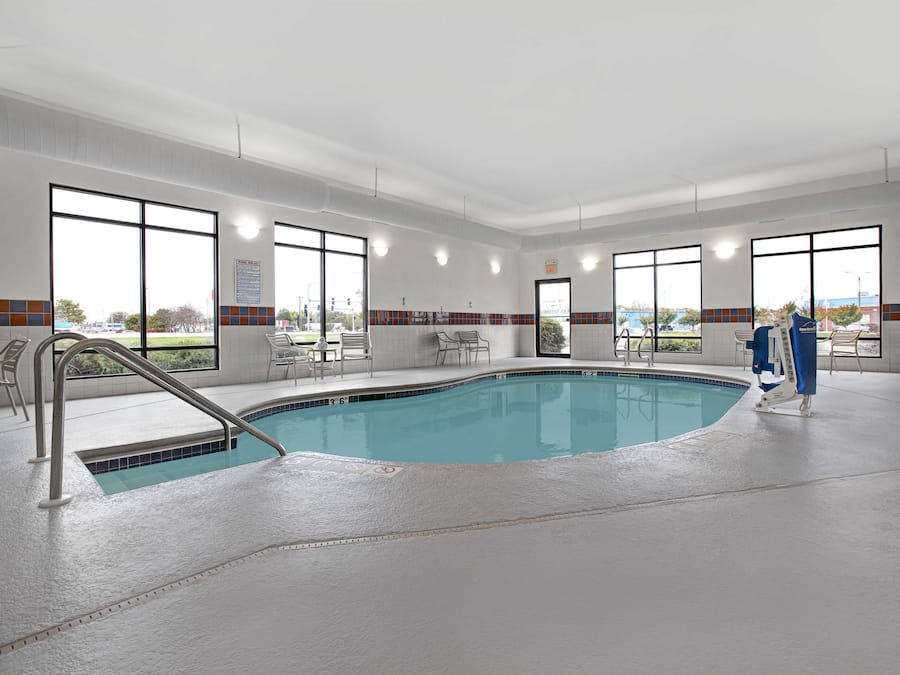 Una piscina techada, sillones reclinables de piscina