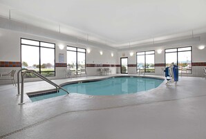 Una piscina techada, sillones reclinables de piscina