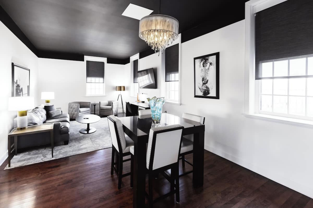 A modern dining area with a chandelier, a dining table, and chairs.