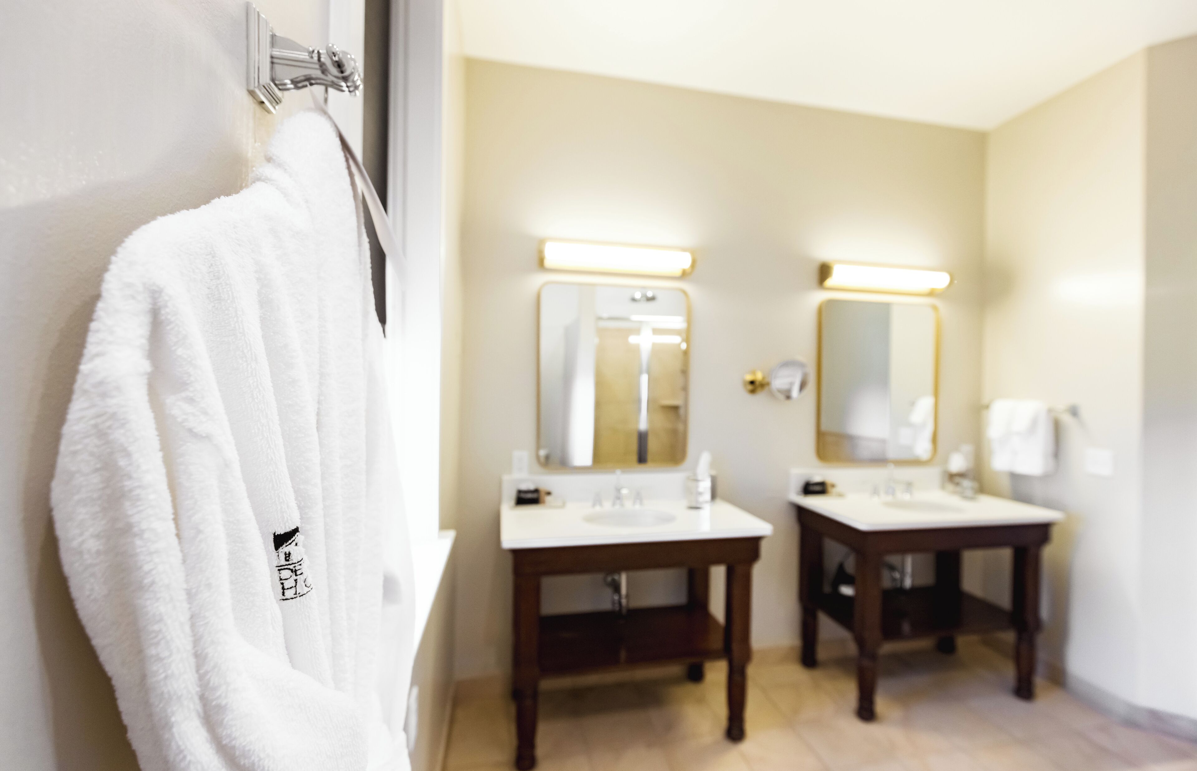 A bathroom with two sinks, a mirror, and a towel rack.