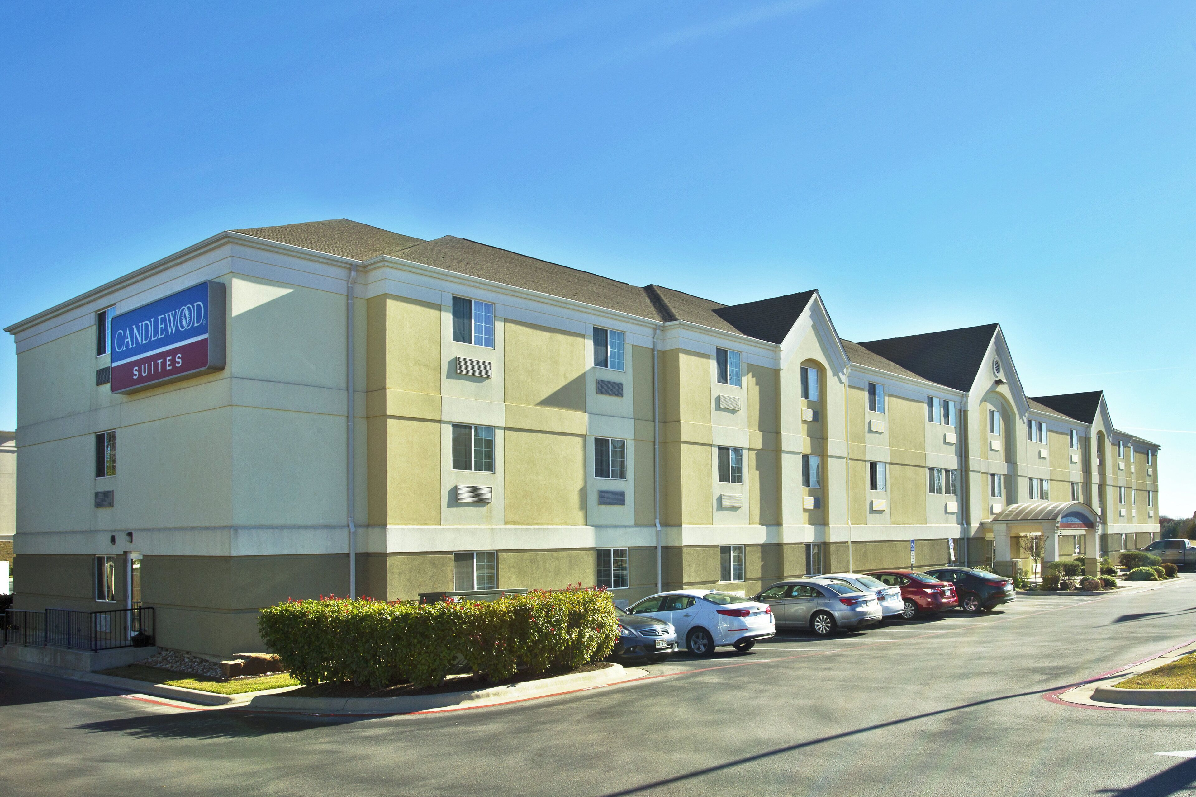 A hotel with a sign indicating 'Candlewood Suites.'