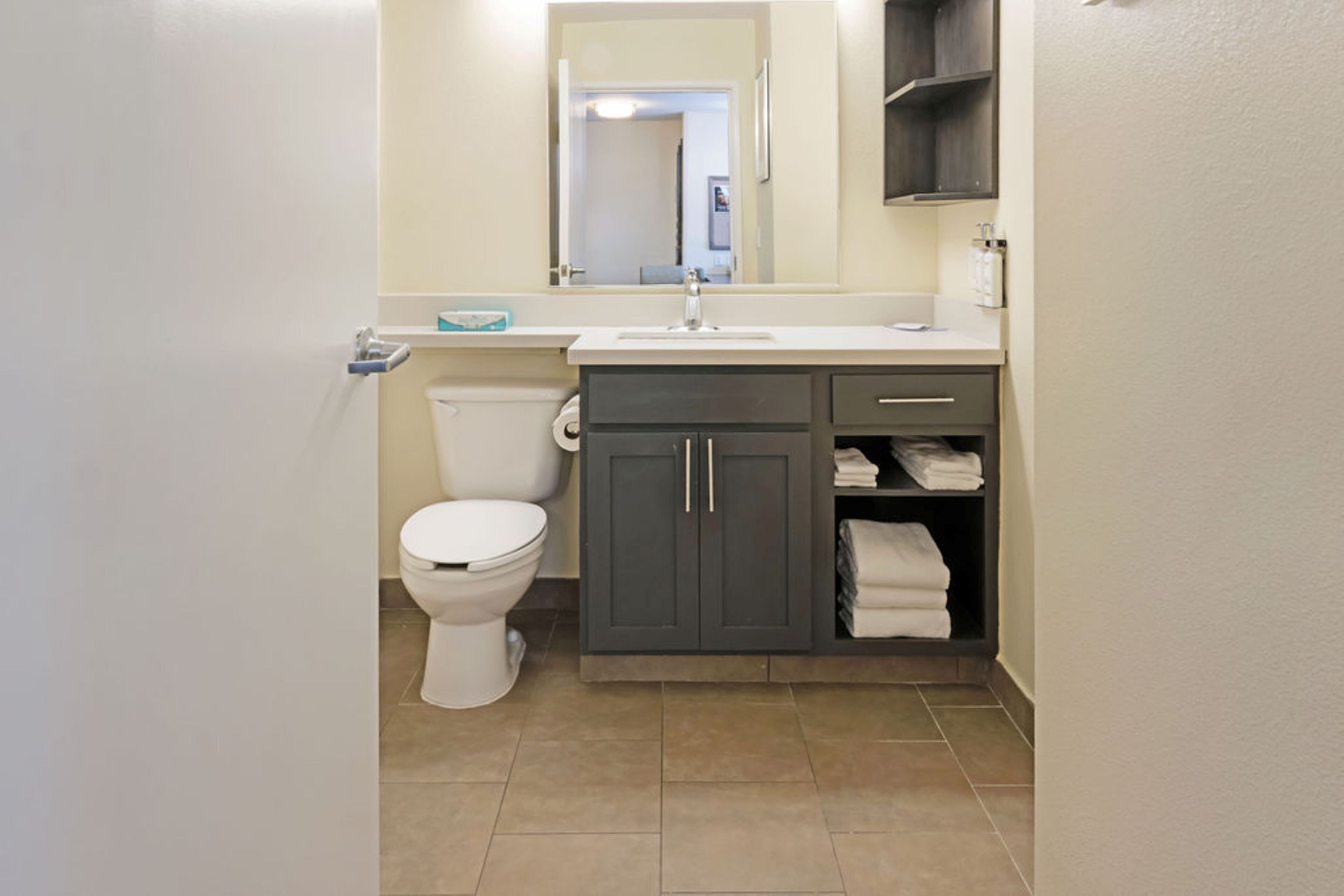A compact bathroom with a toilet, sink, and storage cabinets.