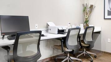 Un bureau moderne équipé d’un bureau, d’un ordinateur, d’une imprimante et de chaises de bureau.