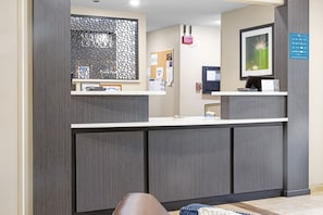 A reception desk with a computer, a framed picture, and a bulletin board. - Candlewood Suites Killeen - Fort Hood Area by IHG (Killeen)