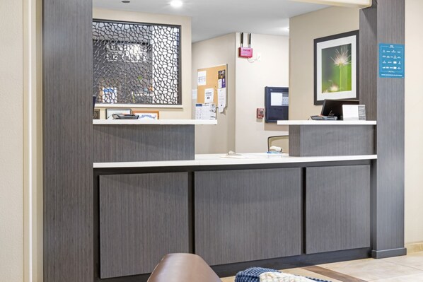 A reception desk with a computer, a framed picture, and a bulletin board. - Candlewood Suites Killeen - Fort Hood Area by IHG (Killeen)