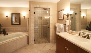 Une salle de bain équipée d’une baignoire, d’une douche, d’un meuble-lavabo avec miroir et d’un sèche-cheveux.