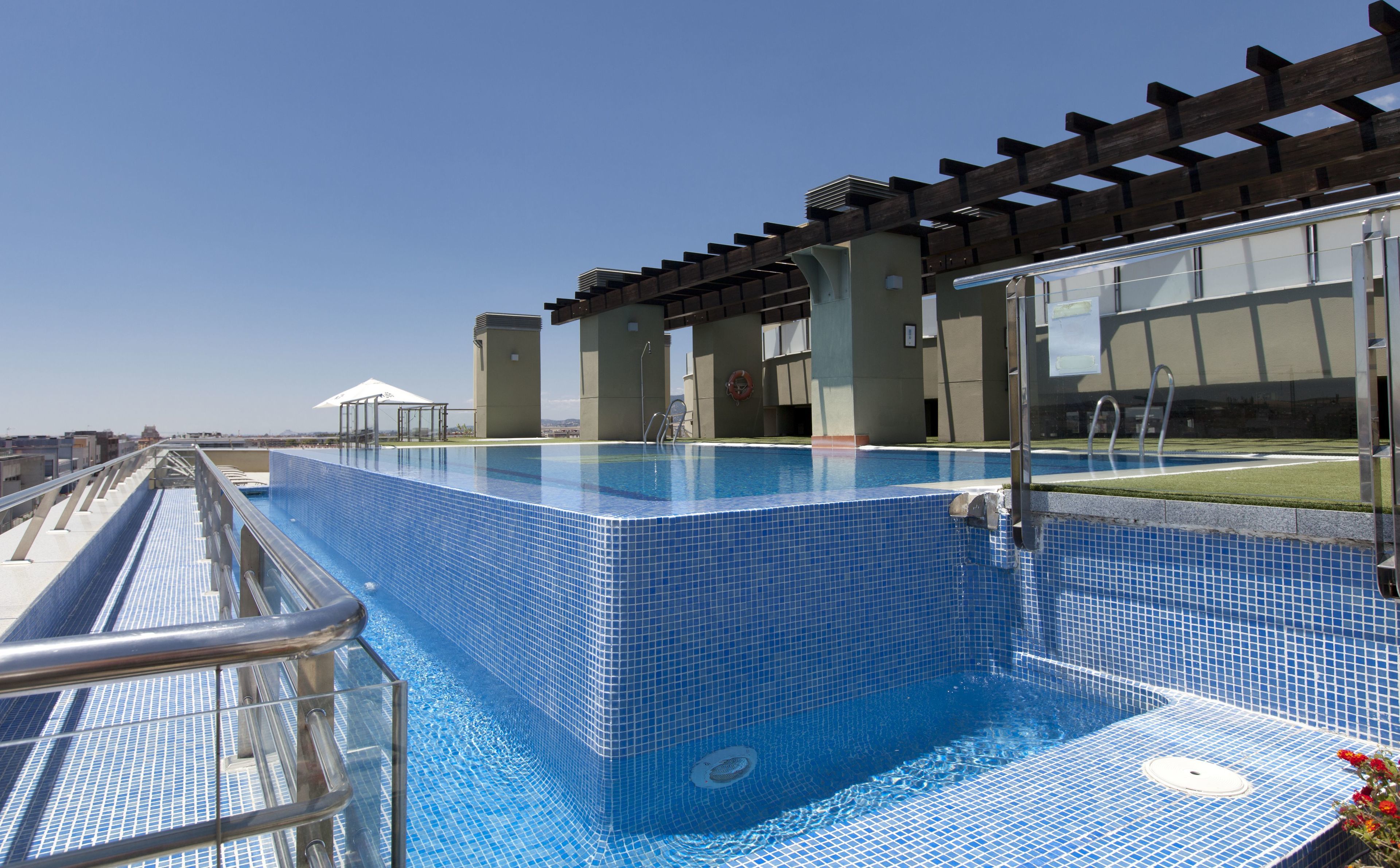 A rooftop swimming pool with a clear view of the city skyline.