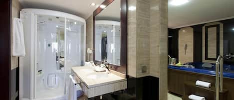 A modern bathroom with a walk-in shower, a large mirror, and a vanity with a sink.