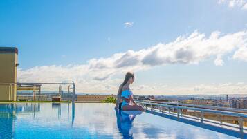 Una piscina al aire libre, sombrillas, tumbonas