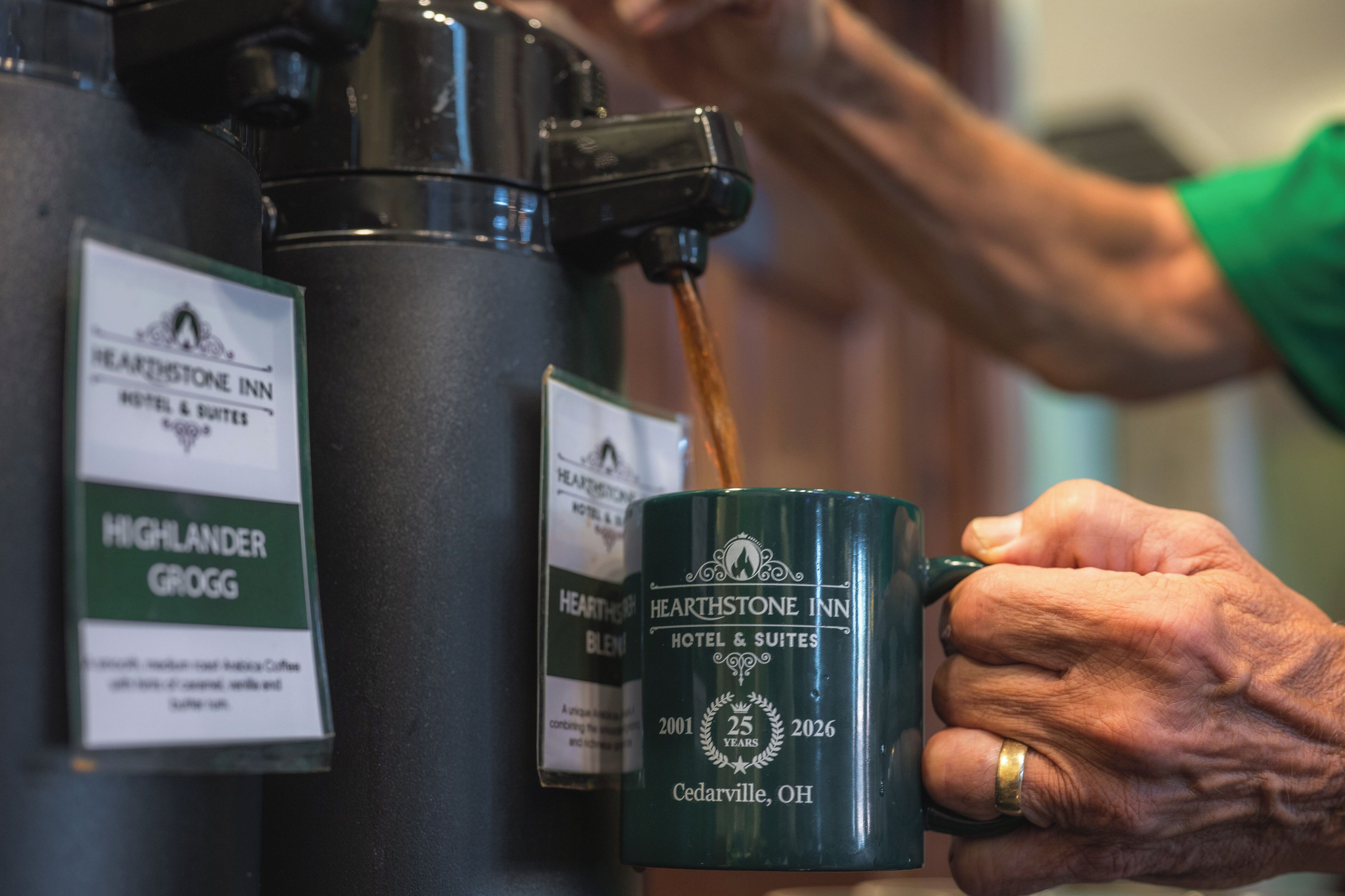A coffee dispenser with a label for Hearthstone Inn Hotel & Suites.