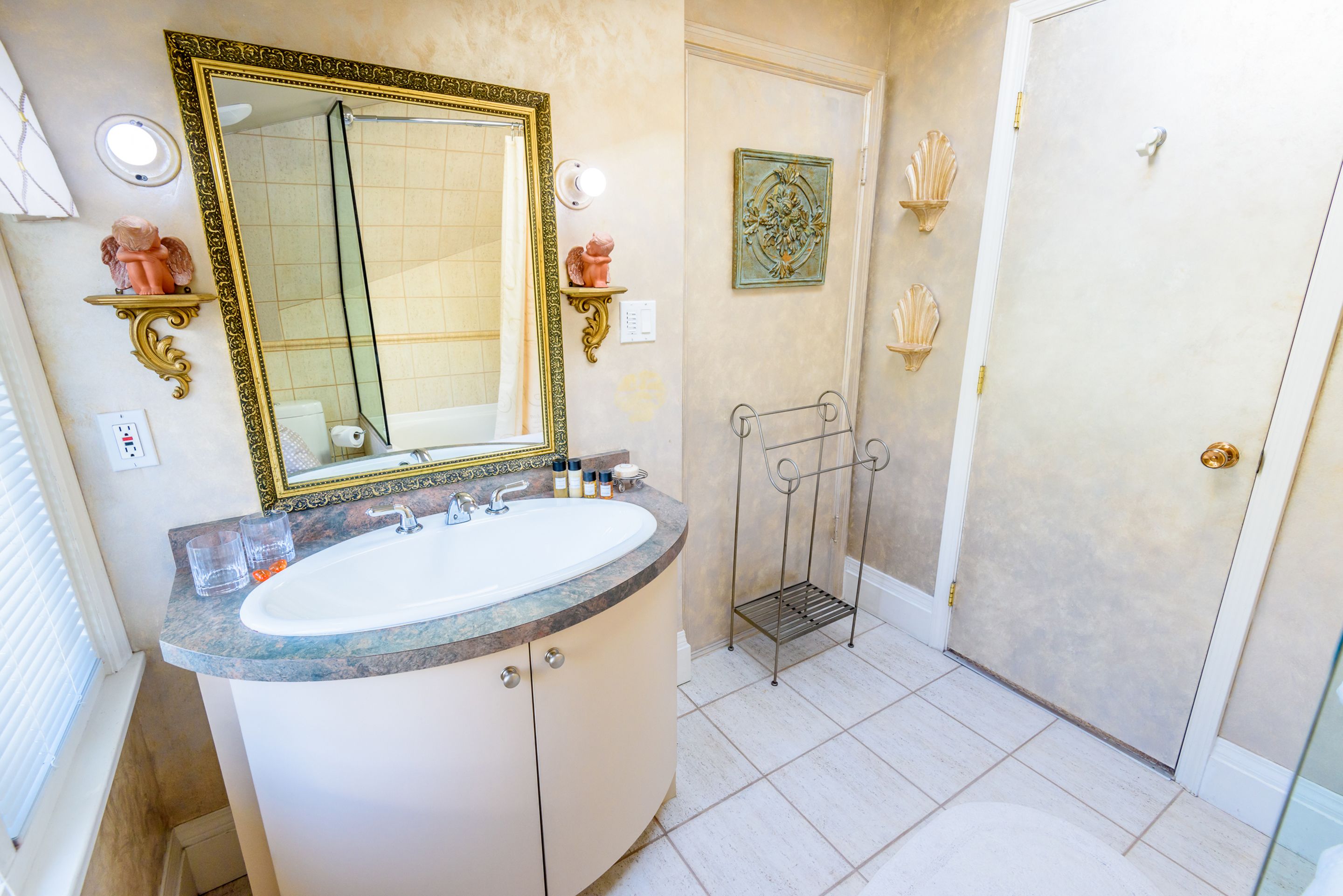 A bathroom with a large mirror, a sink, and a shower area.