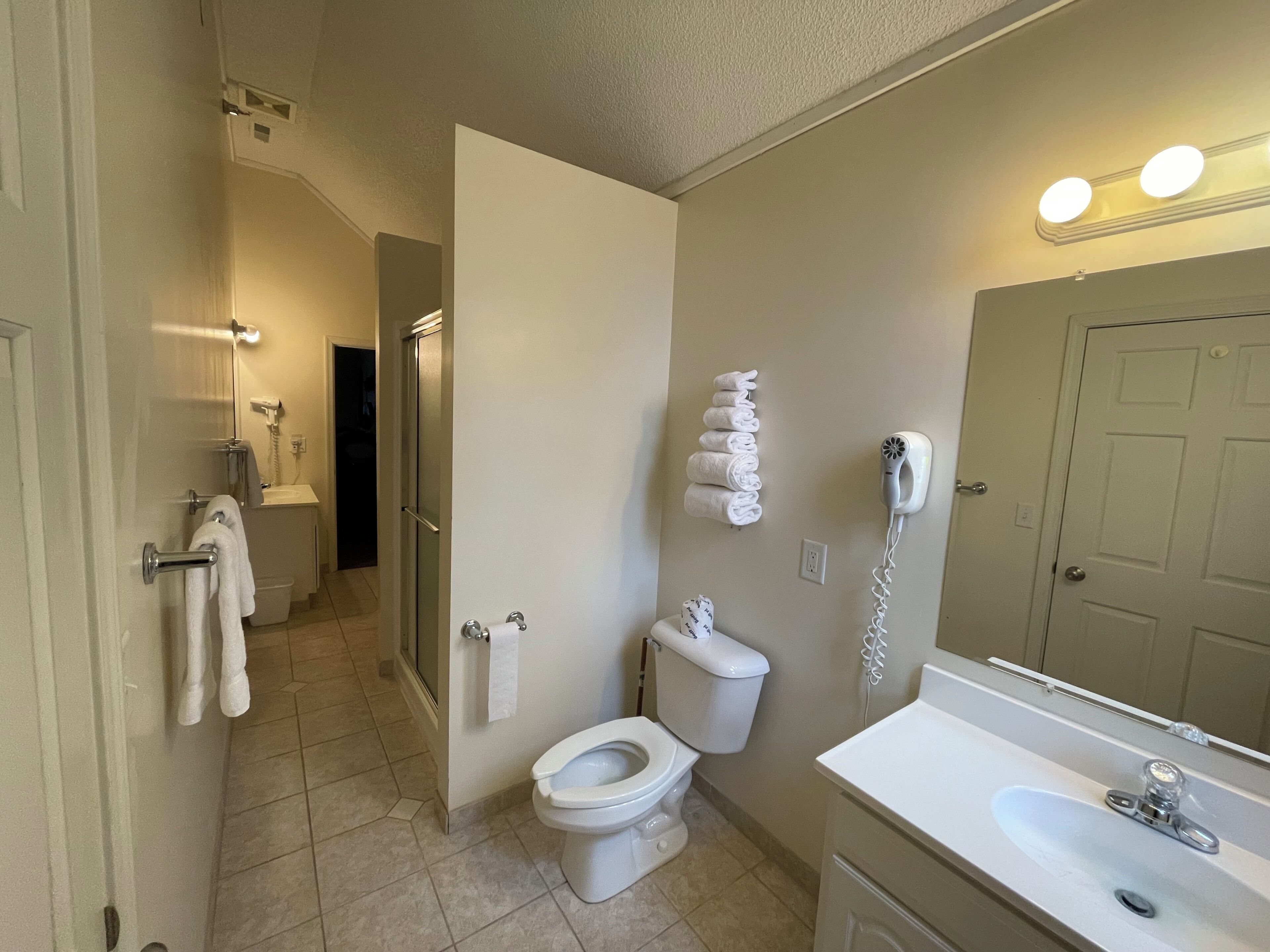 A bathroom with a toilet, sink, and a towel rack.
