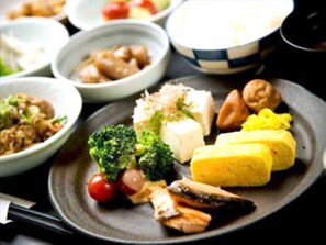 Un plato con diferentes alimentos, entre ellos tofu, brócoli y pescado.