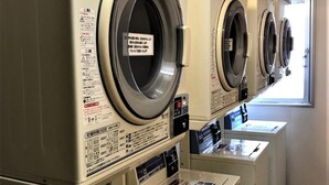 A row of front-loading washers and dryers in a commercial setting. - Chisun Hotel Koriyama (Koriyama)