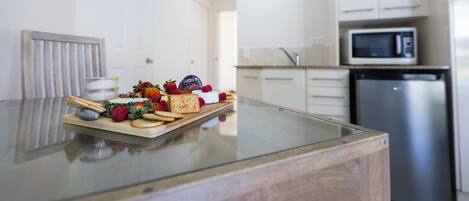 Een moderne keuken met witte kasten, een roestvrijstalen vaatwasser en een magnetron.