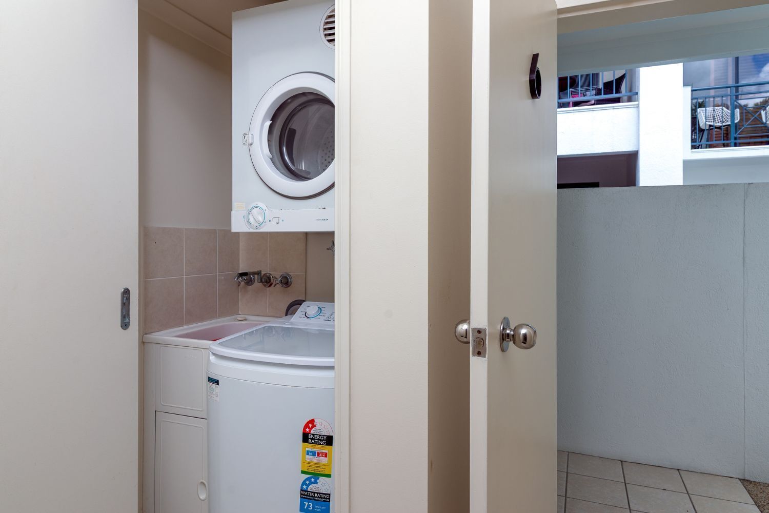 Ein kleiner Hauswirtschaftsraum mit Waschmaschine, Trockner und Warmwasserbereiter.