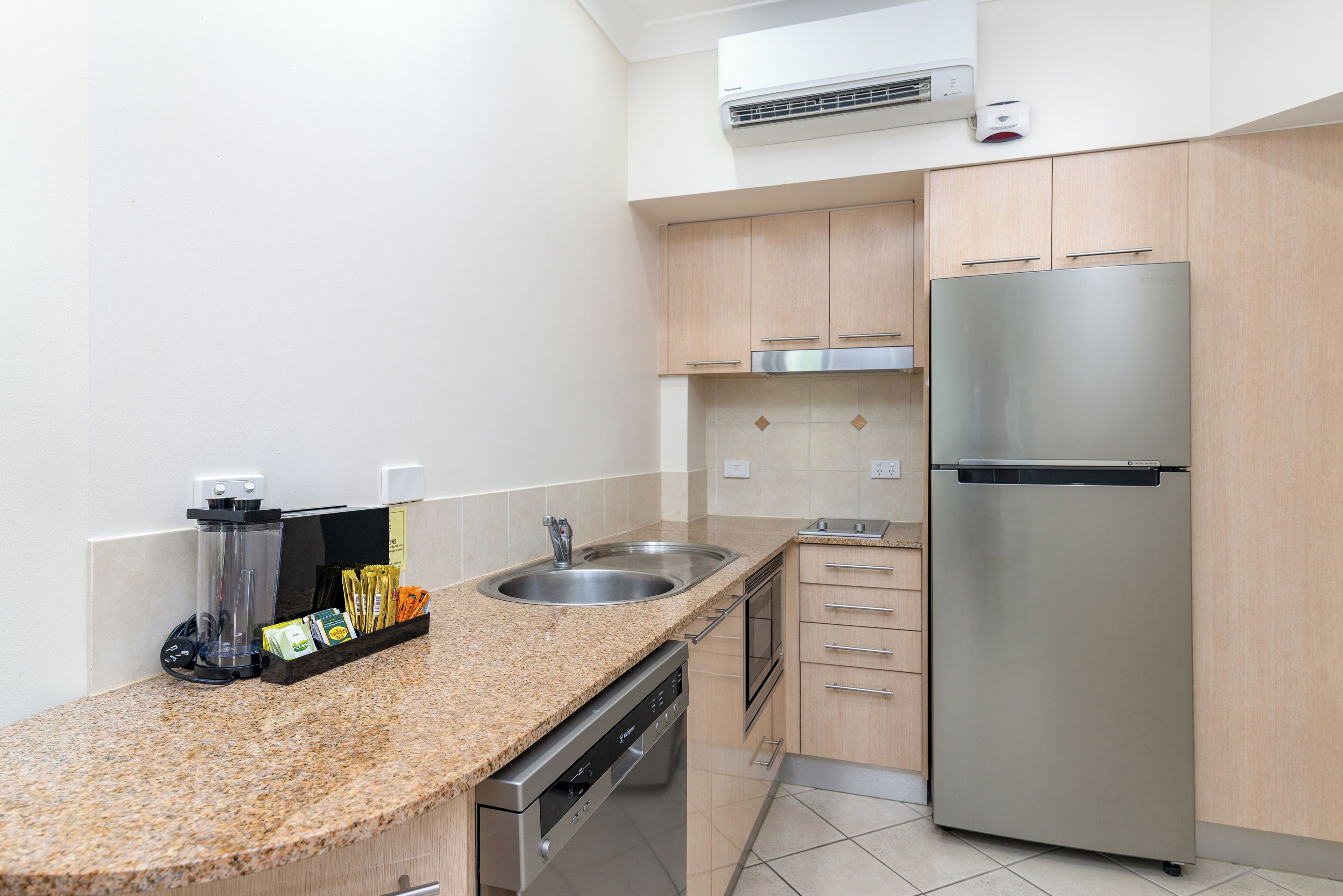 A modern kitchen with granite countertops, stainless steel appliances, and wooden cabinets.
