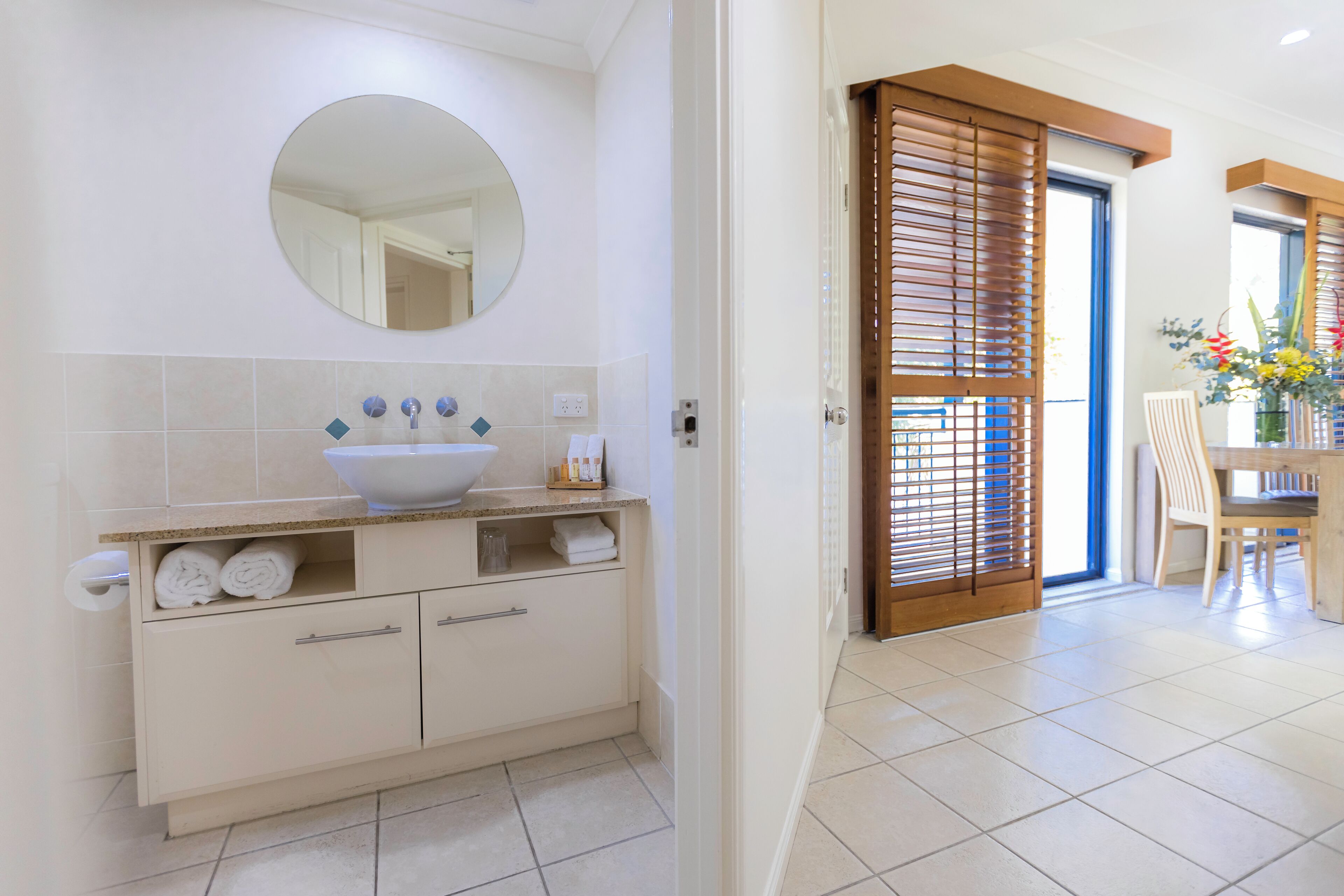 A modern bathroom with a large sink, a mirror, and a toilet.