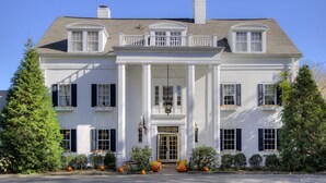 A large, white colonial-style building with a symmetrical facade, central entrance, and a balcony with a railing. - The Kittle House Inn (Chappaqua)