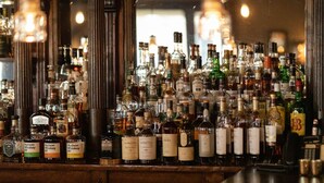 A bar with a variety of liquor bottles displayed on shelves. - The Kittle House Inn (Chappaqua)