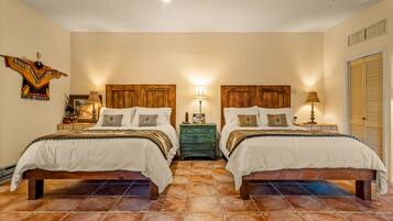 Una habitación doble con dos camas, cabeceros de madera, una mesita de noche verde y una lámpara de pared.