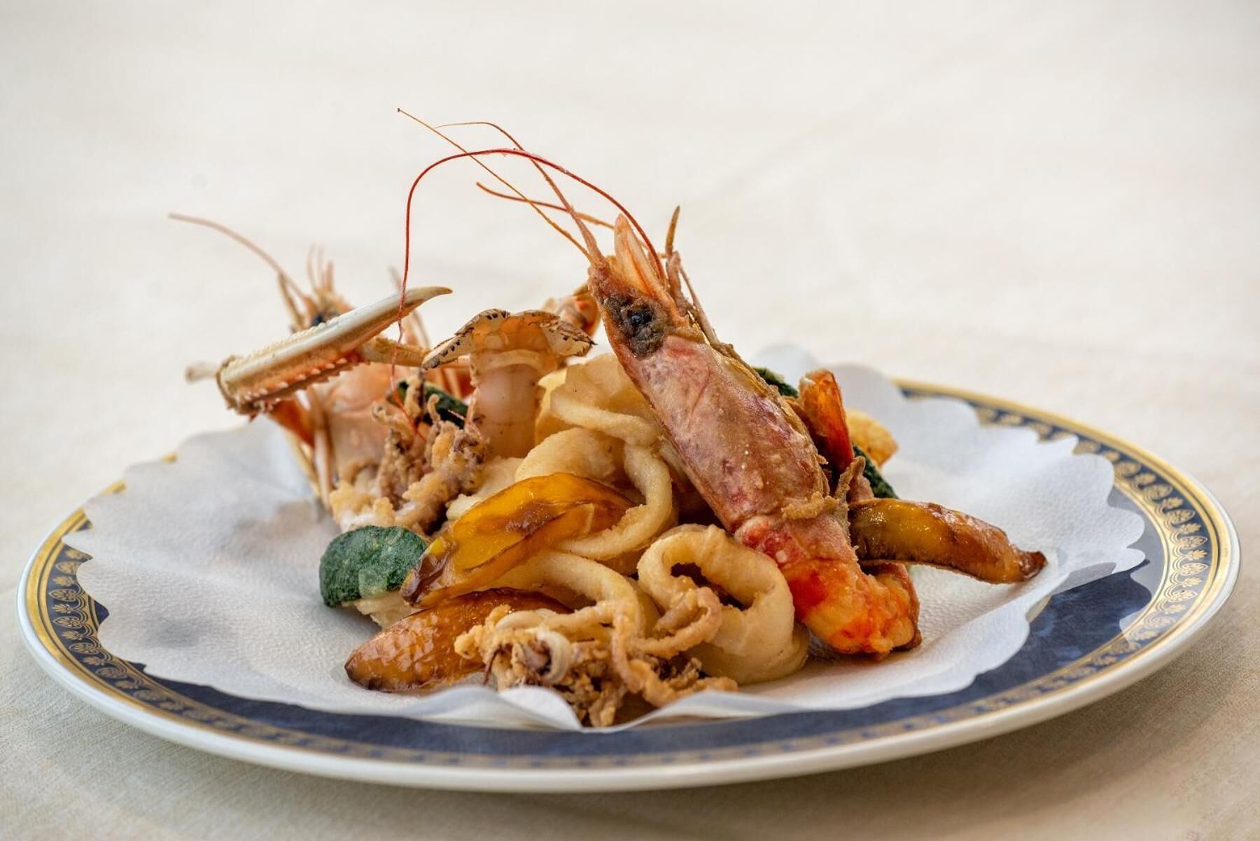 A plate of seafood including shrimp and squid, served on a decorative plate.