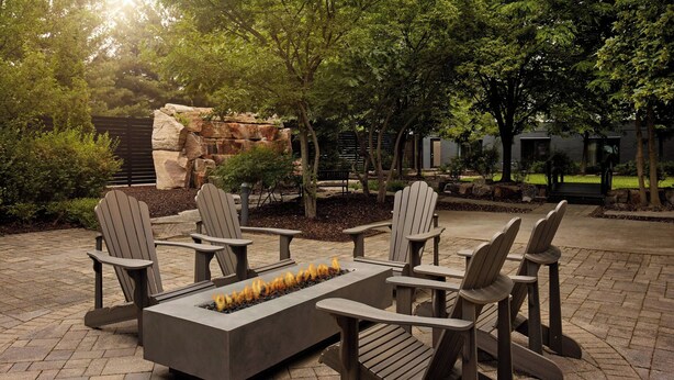 Un espace extérieur aménagé avec des chaises Adirondack et un foyer.