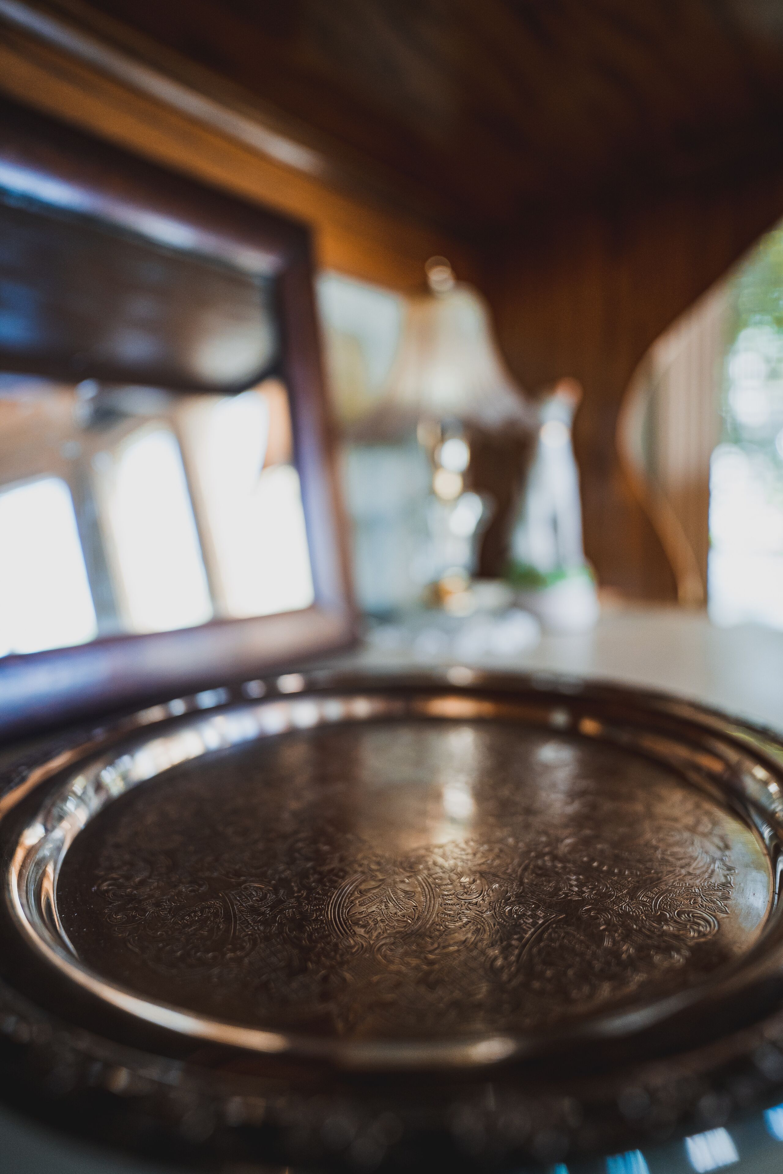 A close-up of a metallic tray with intricate designs, placed on a wooden surface.