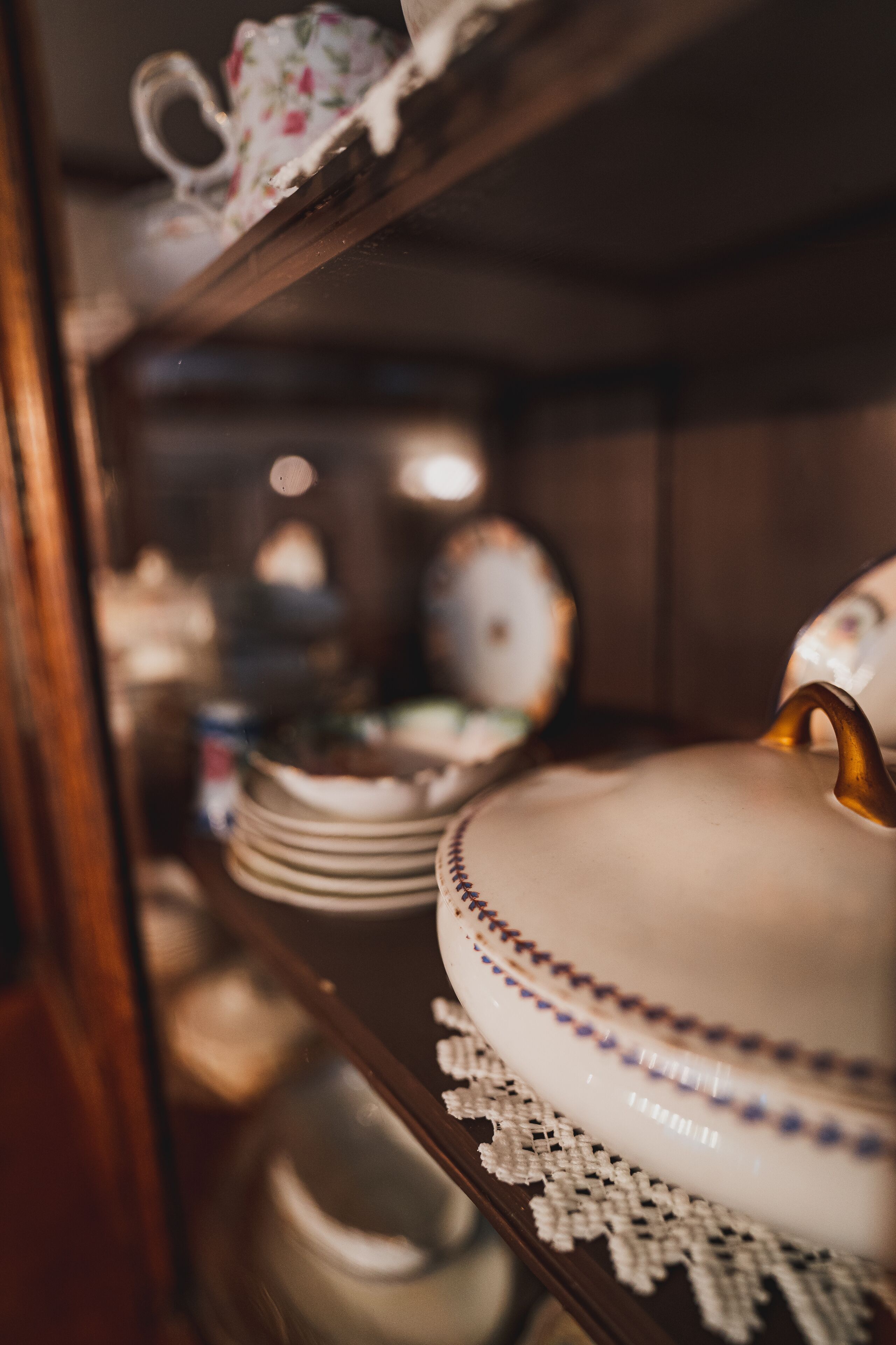 A close-up of a shelf with various dishes and a teapot.