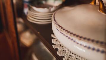 A close-up of a shelf with various dishes and a teapot.