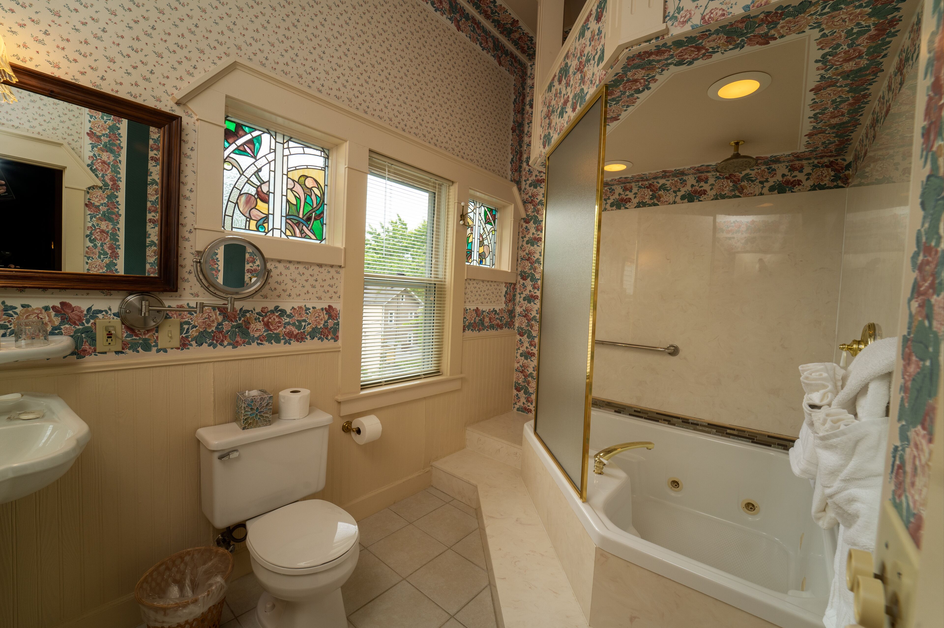 A bathroom with a toilet, sink, bathtub, and shower.