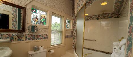 A bathroom with a toilet, sink, bathtub, and shower.