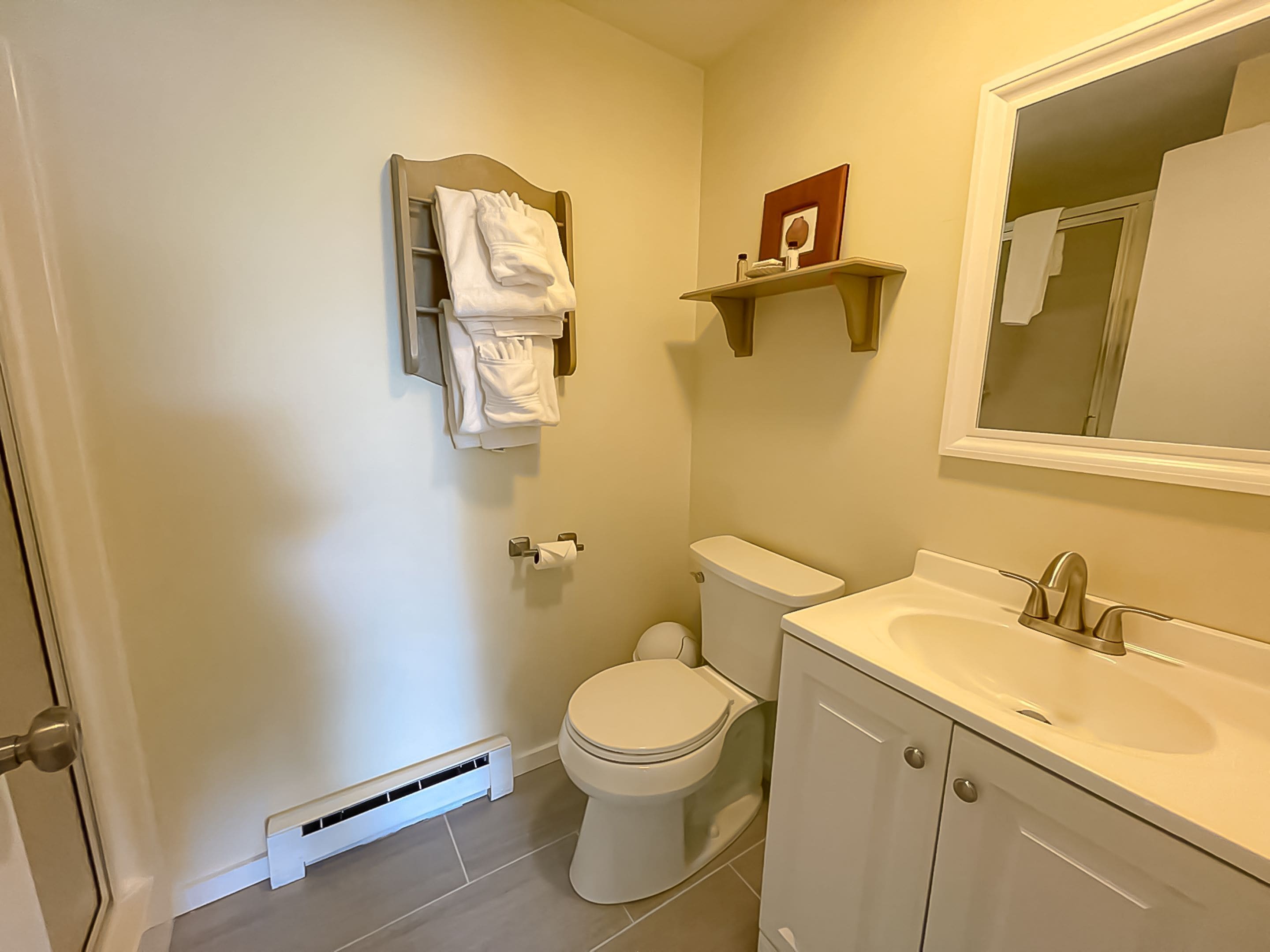 A bathroom with a toilet, sink, and towel rack.
