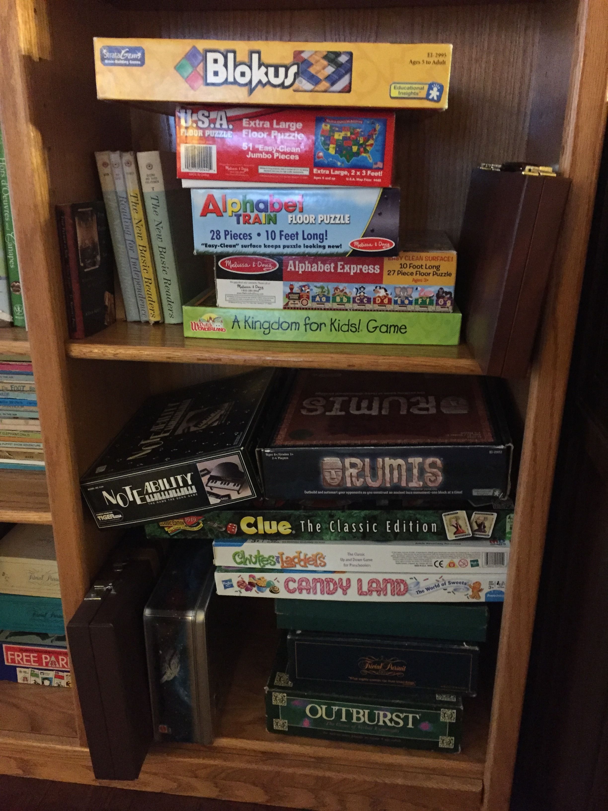 A bookshelf with various board games and books.