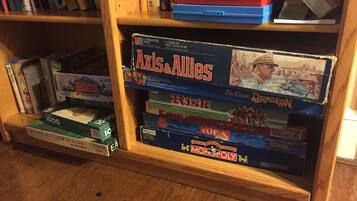 A bookshelf with various board games including Axis & Allies, Risk, and Monopoly.