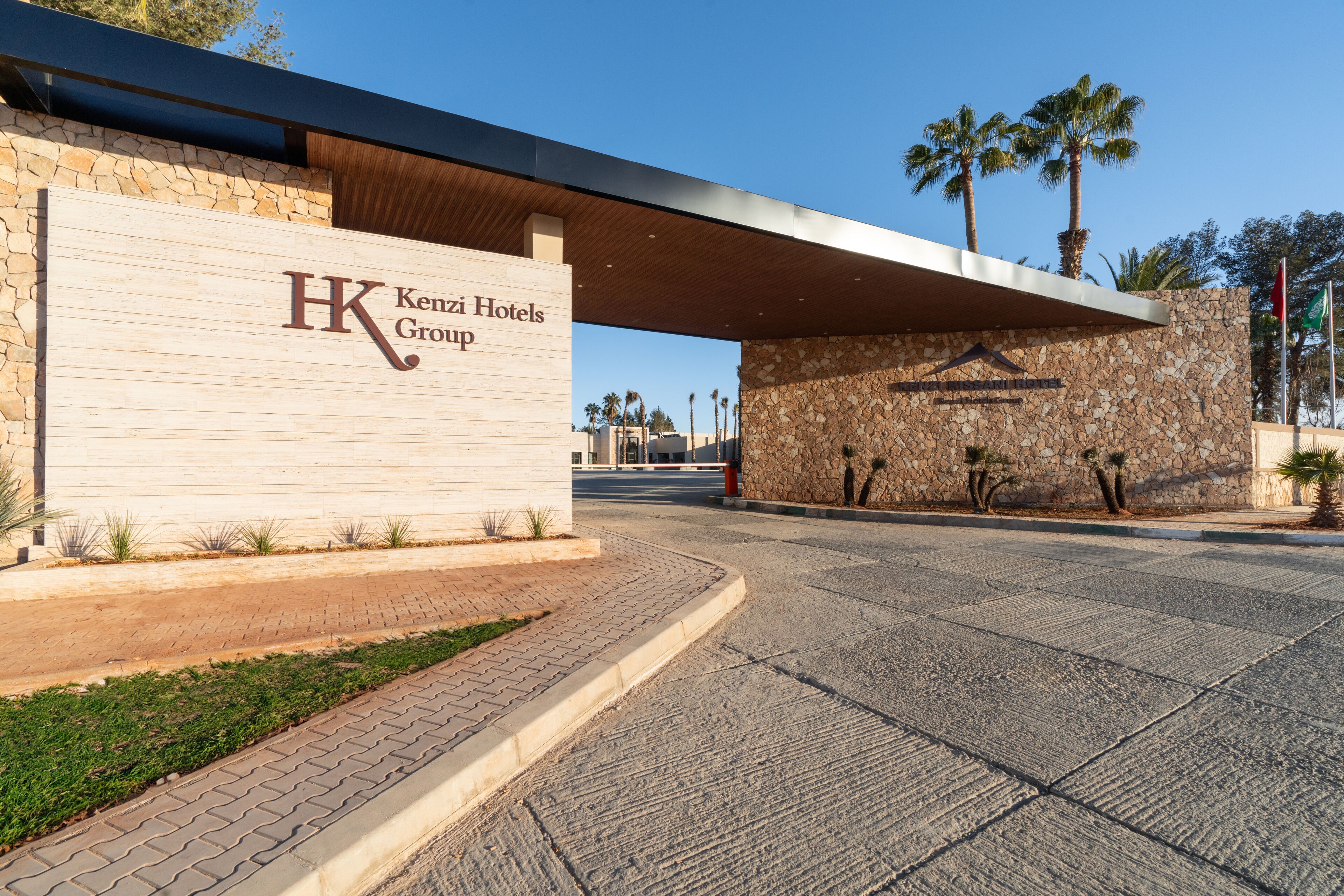 A hotel entrance with a stone facade and a modern overhang.