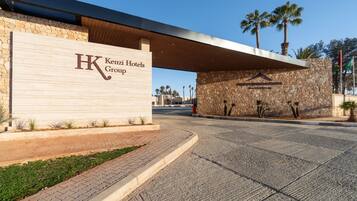 A hotel entrance with a stone facade and a modern overhang.