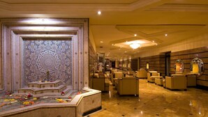 A luxurious lobby with a decorative fountain, plush seating, and a patterned wall. - Atlas Asni (Marrakech)