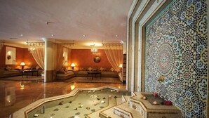 A luxurious lobby with a central seating area, a decorative pool, and intricate tile work on the walls. - Atlas Asni (Marrakech)