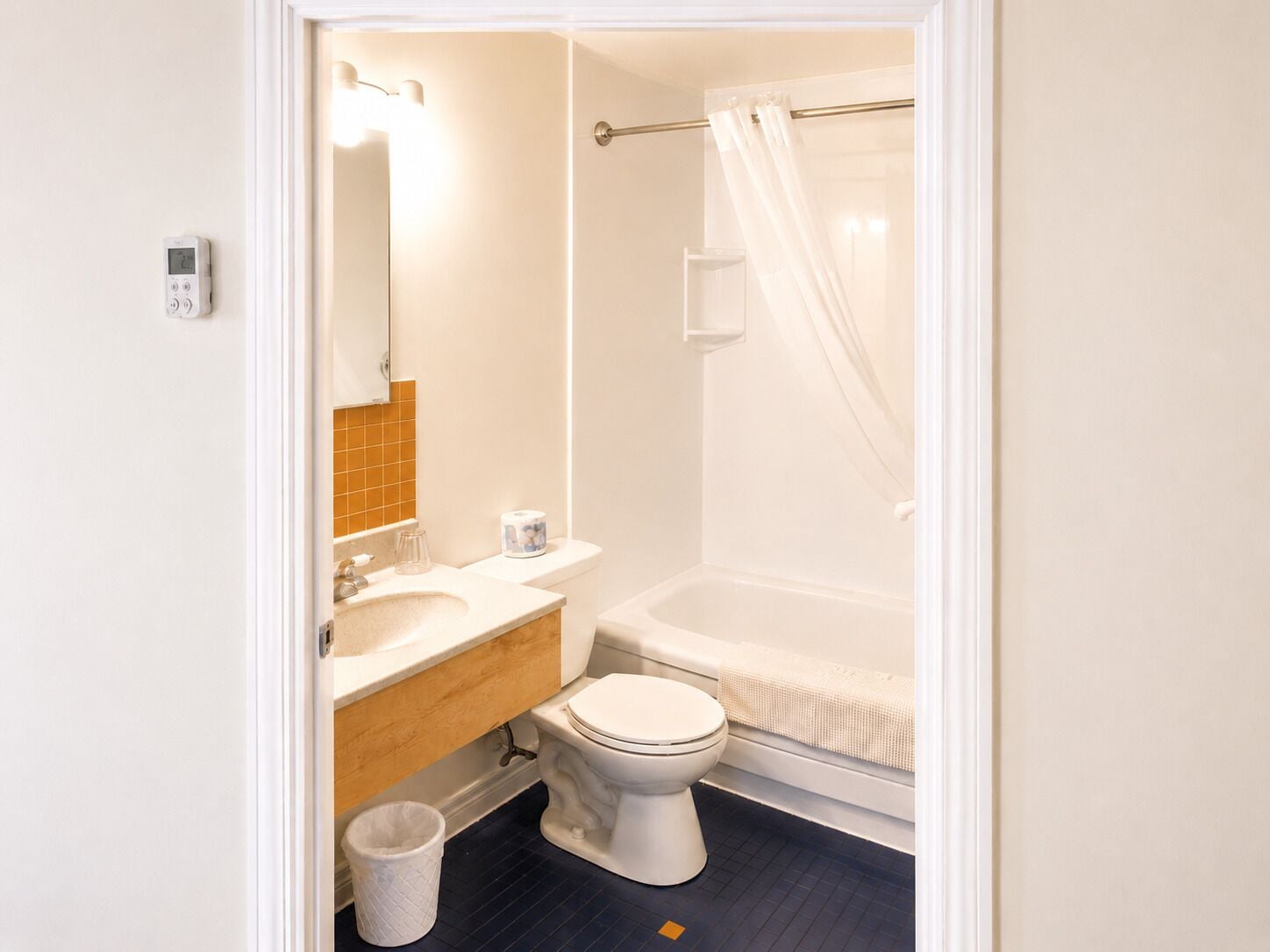 Un baño con inodoro, lavamanos, espejo y cortina de ducha.