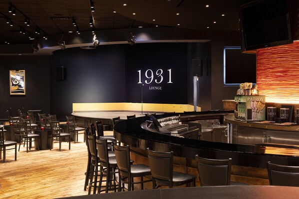 A bar area with a counter, bar stools, and a wall displaying '1931 Lounge'.