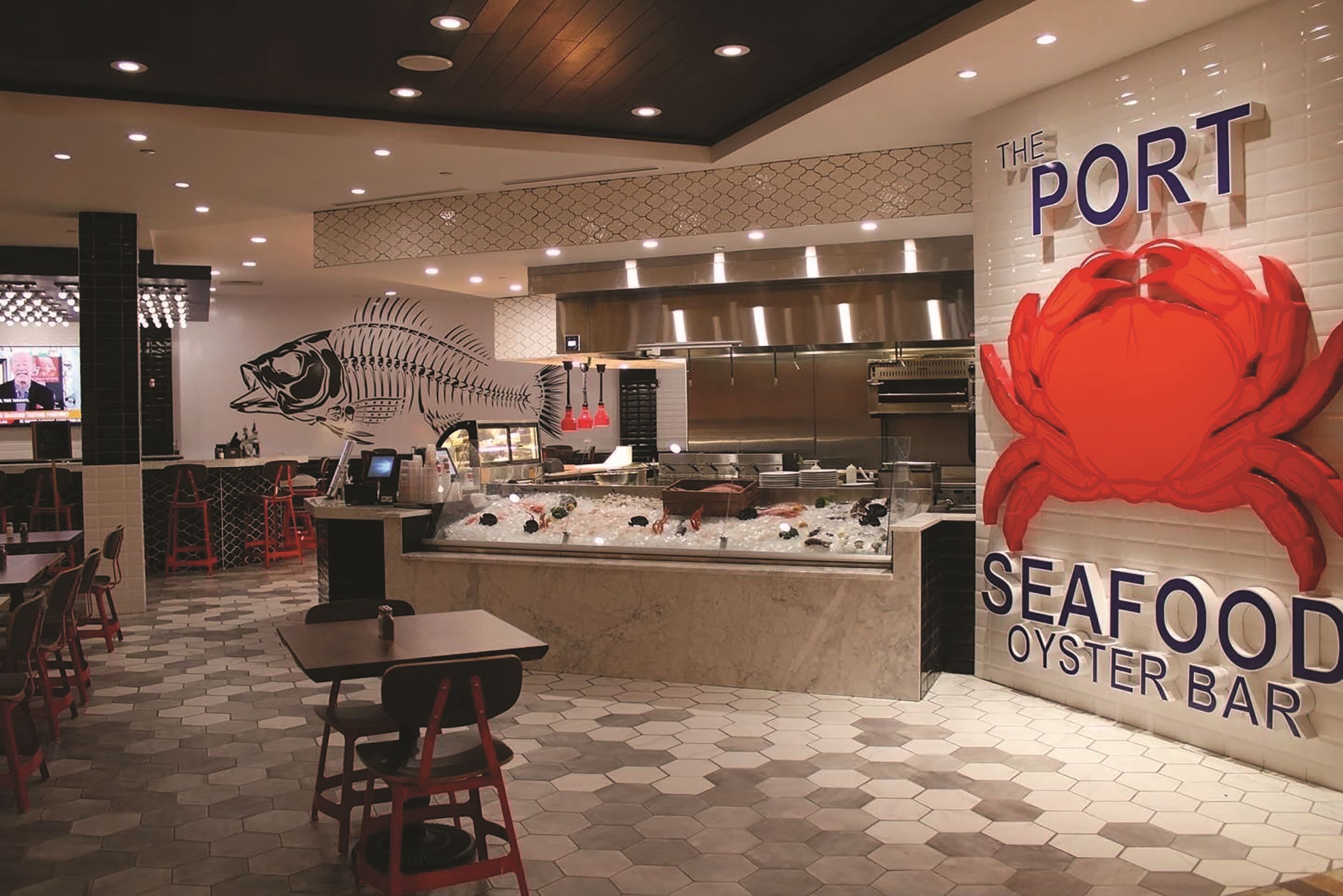 Een restaurantinterieur met zeevruchten, met een grote visgraat decoratie, een bord met 'zeevruchtenbar' en een toonbank met keukenapparatuur.
