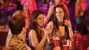 A group of people seated at a bar with drinks, suggesting a social setting.