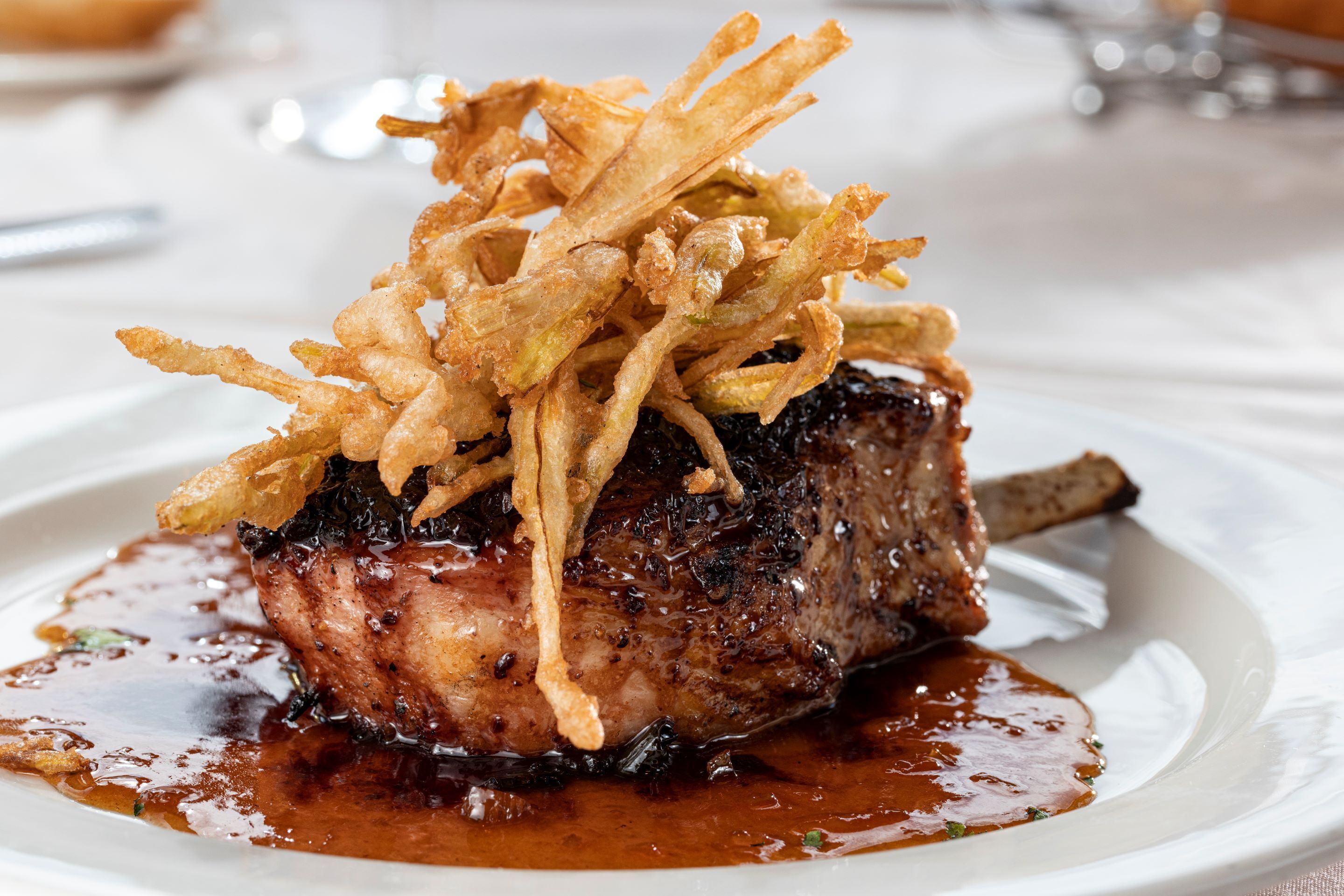 A steak with crispy fries on a plate.
