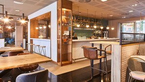 A modern bar area with wooden and metal furniture, a bar counter, and a view of the street outside.