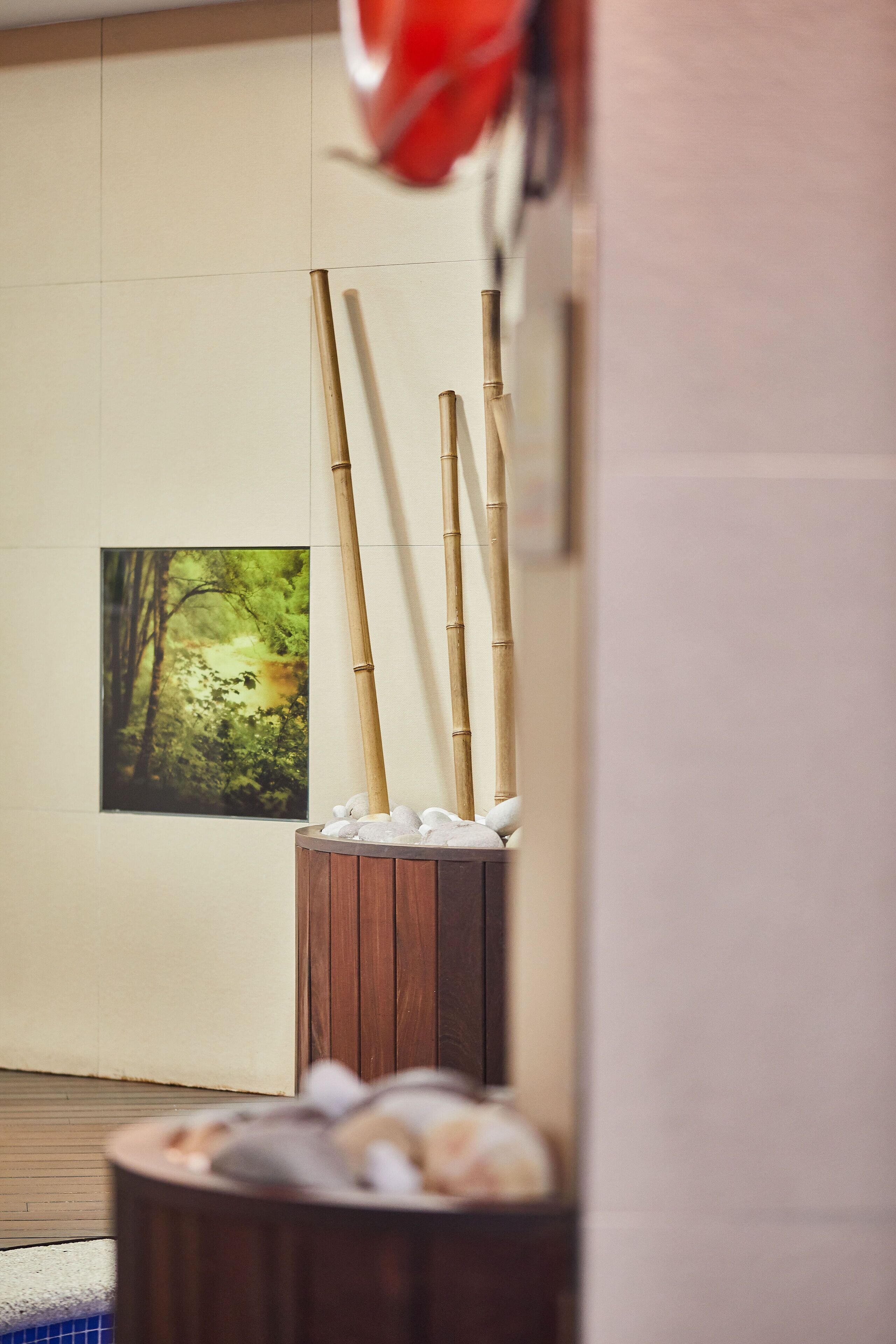 Una habitación con piso de madera, un armario de madera con toallas y un cuadro enmarcado en la pared.